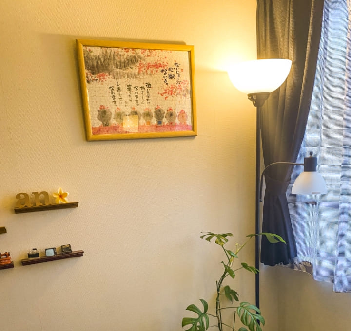 施術ルームの内装（壁に掛けられたイラストや植物）の写真